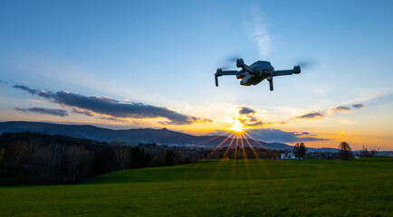 Fototapeta na wymiar Drone silhouette at sunset time. Unmanned aerial vehicle, UAV, or uncrewed aerial vehicle.