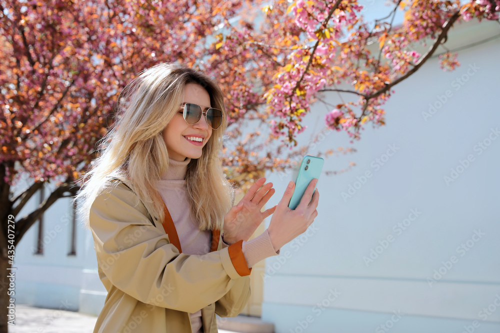 Sticker young woman taking selfie on city street