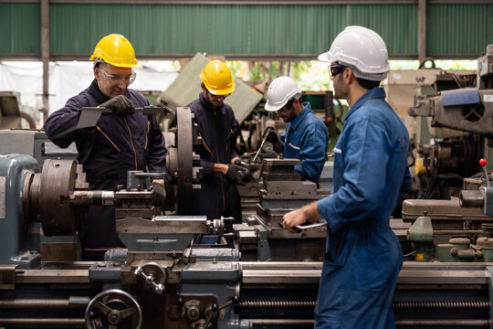 Group of male engineer worker maintenance machine in industry factory. Male technician worker working, repair machine lathe metal in the industry factory