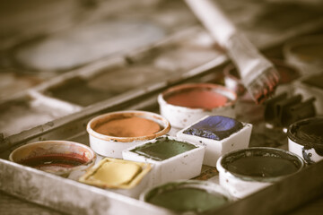 Old paint box with aquarelle watercolors with brush, antique vintage style, desaturated colours,...