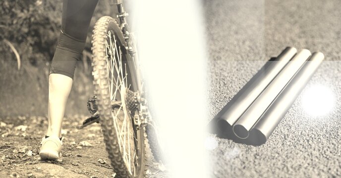 Composition of low section of cyclist with overexposure and metal pipes on road in sepia tone