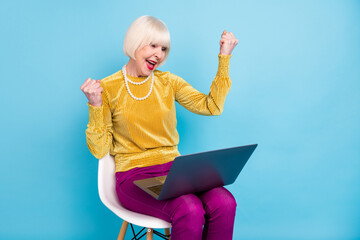 Photo of hooray short hairdo aged lady sit with laptop wear blouse pants isolated on blue color...