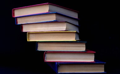 Colorful books are stacked in a stack in the form of a ladder. Ladder of Knowledge
