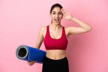 Young sport caucasian woman going to yoga classes while holding a mat with surprise expression