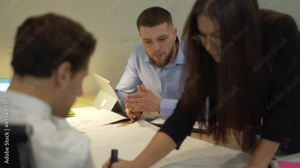 Poster group of caucasian developers analyzing blueprint sketches during corporate brainstorming in office,