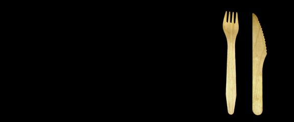 Wooden spoon and knife on a black background in the right corner
