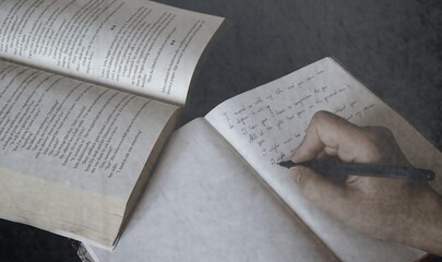 A woman's hand. Rewrites the text from the book. Composes and writes short stories. Black and white...