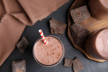Delicious chocolate milk on black table, flat lay