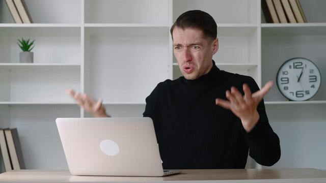 Portrait of shocked male businessman looking at laptop, takes off glasses and say What. Surprised and scared man on modern office interior background. Indignant and dissenting guy say no with disgust