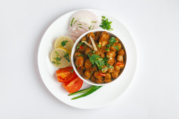 Chickpeas masala (Spicy chola or chhole curry)  garnished with fresh green coriander and ingredients. Served in a ceramic bowl. An Classic Indian typical Panjabi street food.  