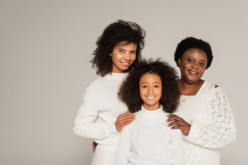 happy african american family of grandmother, daughter and granddaughter standing together isolated...