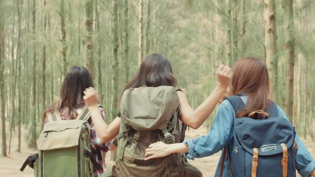 Asian hiker women trekking in forest. Young happy backpack girls walking enjoy her journey, travel nature and adventure trip, climb mountain lot of tree in fall holidays vacation concept.