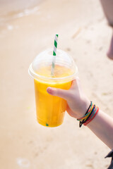ice drink juice yellow lemonade on the beach sea coast shore, orange fresh summer surf wave background refreshing drink relax positive mood vacation top view