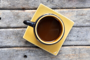 Cup of hot coffee on an old wooden table.