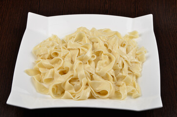 boiled vermicelli pasta in a white plate on a wooden background