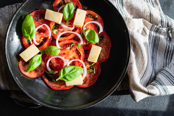 tomato salad veggie vegetable, cheese, onion diet vitamin on the table healthy food keto or paleo diet meal snack copy space food background rustic. top view vegan or vegetarian food