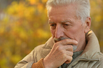 portrait of thinking senior man  in  park