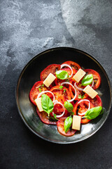 tomato salad veggie vegetable, cheese, onion diet vitamin on the table healthy food keto or paleo diet meal snack copy space food background rustic. top view vegan or vegetarian food