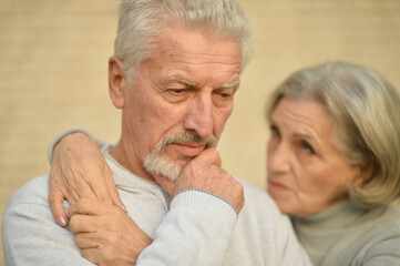 Sad thoughtful senior couple in  park