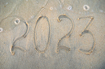 New year, number 2023 on beach sand. Holiday concept.