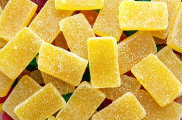 Yellow rectangular jelly candies pattern background. Yellow rectangular shaped marmalade backdrop