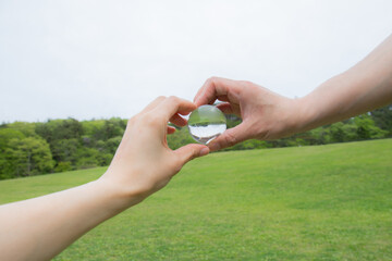 二人の手で透明な地球を持っている