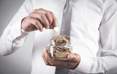 Man holding jar of coins.