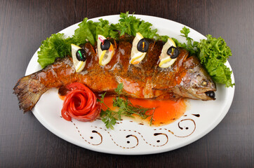 fried fish with lemon slices and olives