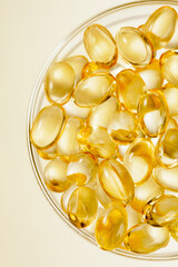 Colse up of Vitamin supplement capsules in glass dish on white background.