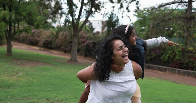 Happy indian mother having fun outdoor with daughter - Mother and child love concept 