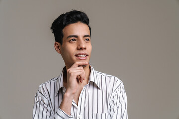 Brunette hispanic man in shirt smiling and looking aside