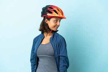 Young cyclist woman isolated on blue background . Portrait - obrazy, fototapety, plakaty