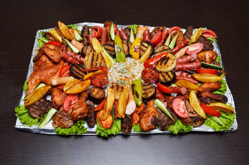 Tray with pieces of beef and chicken, baked vegetables, beautifully served in a restaurant, Asian cuisine