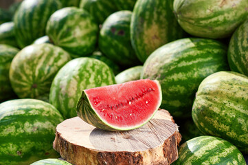 A piece of juicy red watermelon on a wooden tray.