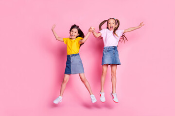 Full size photo of nice optimistic blond brown hair girls jump wear t-shirt isolated on pink background