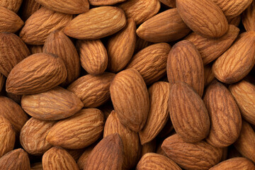 Peeled whole brown almonds close up full frame as a background 