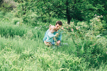 Naklejka na ściany i meble daughter with father in a field with flowers. international day of men. father's day. great father. destruction of gender stereotypes