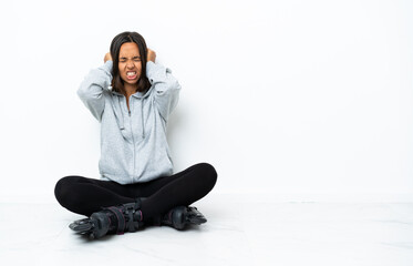 Young asian woman with roller skates on the floor frustrated and covering ears