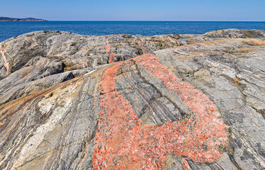 Smooth-cut bare rocks with a pink pegmatite dyke at the coast of the Barents sea in the vicinity of Grense Jakobselv, Finnmark, Norway