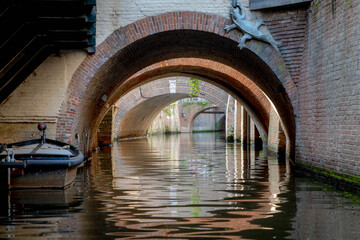 A view under the bridges with reflection on water of canal, 's-Hertogenbosch colloquially known as...
