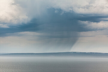 Coast of the Varanger peninsula disappears in a rain shower, Finnmark, Norway