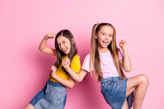 Photo of hooray brunette blond girls hands fists wear yellow pink t-shirt skirts isolated on pink color background