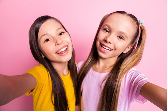 Photo of optimistic brunette blond girls do selfie wear yellow pink t-shirt isolated on pink color background
