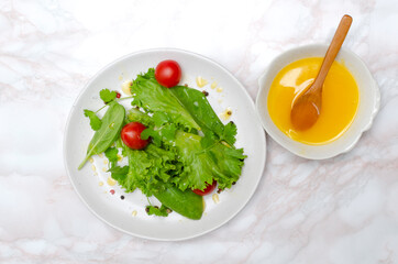 Top view of fresh vegetable salad, ghee liquid butter on the kitchen table