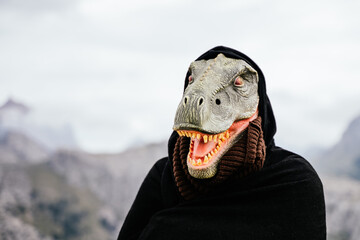 Caucasian man with a smiling dinosaur mask and a cape in the Sierra de Tramuntana. Palma de...