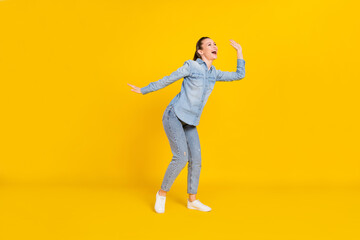 Fototapeta na wymiar Full length photo of shiny funny young woman wear denim shirt smiling dancing isolated yellow color background