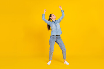 Fototapeta na wymiar Full length photo of pretty funky young lady dressed jeans shirt jumping smiling isolated yellow color background