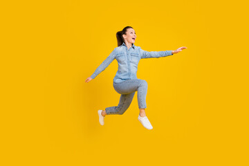 Fototapeta na wymiar Full body profile side photo of amazed excited young happy woman look run empty space jump up isolated on yellow color background
