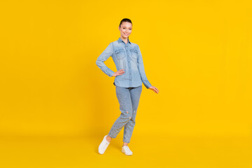 Fototapeta na wymiar Full length photo of cute adorable young woman wear denim shirt smiling standing isolated yellow color background