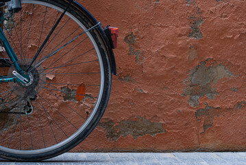 Fototapeta na wymiar Rear bike wheel on orange worn wall. Old style cycling SC